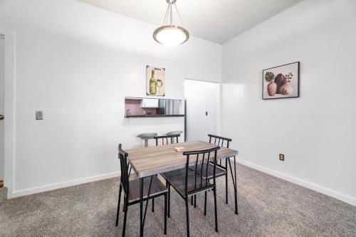a dining room with white walls and a table and chairs at Cozy Condo On Collins- Walk to High St /Dtown /OSU in Columbus