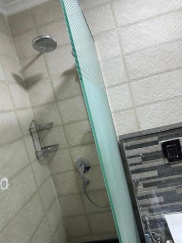a shower with a shower head in a bathroom at شقه مفروشه 3 غرف امام سيتي ستارز in Cairo