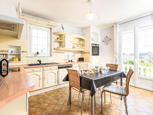 une cuisine avec des armoires blanches et une table et des chaises dans l'établissement Holiday Home Martin by Interhome, à Saint-Père