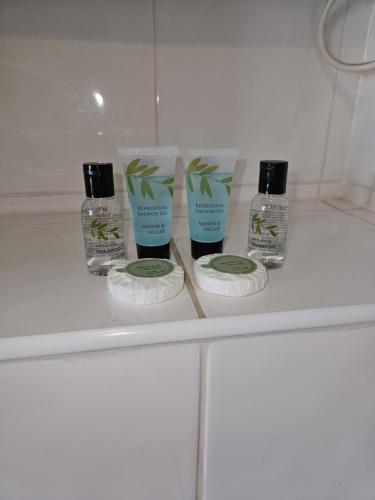 three products on a shelf in a bathroom at Trillberry Guesthouse in Weymouth