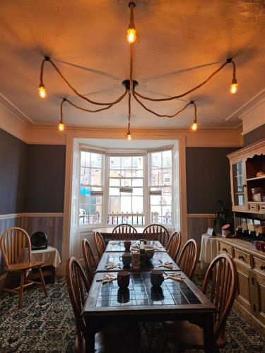 a dining room with a table and chairs and a window at Trillberry Guesthouse in Weymouth