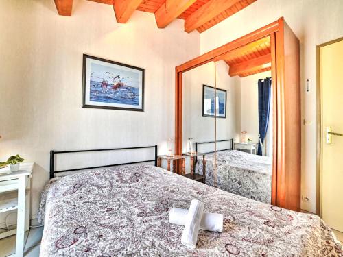 une chambre avec deux lits et un grand miroir dans l'établissement Holiday Home Les voiliers by Interhome, à Saint-Pierre-dʼOléron