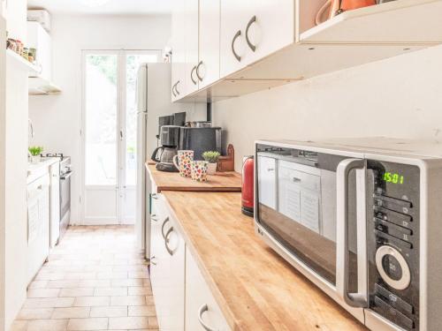 une cuisine avec des armoires blanches et un micro-ondes dans l'établissement Apartment L'Helios by Interhome, à Nice