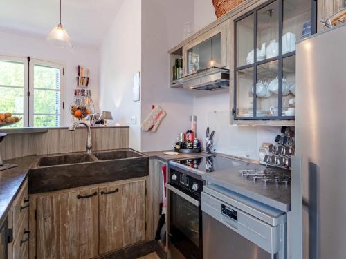 une cuisine avec des armoires en bois et un évier dans l'établissement Apartment Les Jardins de Cabourg by Interhome, à Cabourg