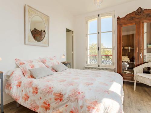 une chambre avec un grand lit avec un couvre-lit fleuri dans l'établissement Apartment Les Jardins de Cabourg by Interhome, à Cabourg