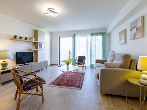 a living room with a couch and a tv at Apartment Océanide by Interhome in La Bernerie-en-Retz
