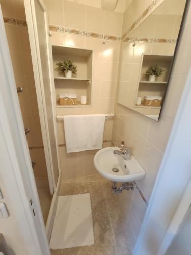 une petite salle de bain avec un lavabo et un miroir dans l'établissement Séjour authentique avec vue mer à Menton, à Menton