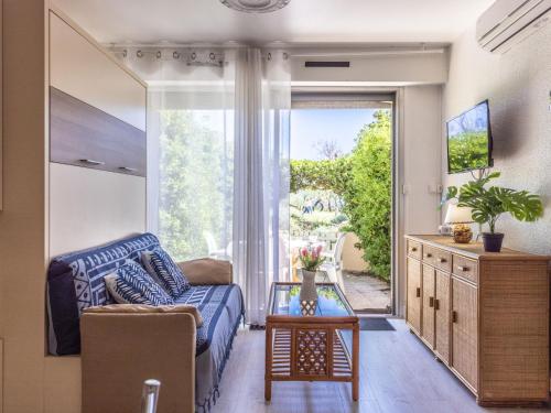 un salon avec un canapé et une grande fenêtre dans l'établissement Studio De La Plage-4 by Interhome, au Cap d'Agde