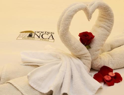 two swans wrapped in towels next to roses at Golden Inca Hotel in Cusco