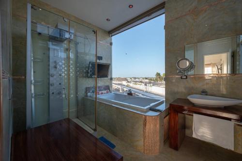 a bathroom with a tub and a sink and a mirror at Modern Apartment in Marina Las Tortugas in Progreso