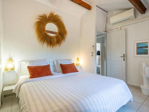 une chambre avec un grand lit blanc avec des oreillers orange dans l'établissement Villa Le 444 by Interhome, à Cogolin