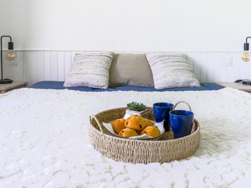 a tray of fruit on a bed with blue cups at Holiday Home Villa la Bergerie by Interhome in Nice