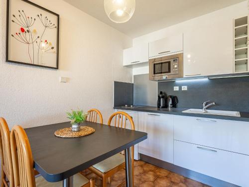 - une cuisine avec une table, des chaises et un évier dans l'établissement Apartment Les Regates-7 by Interhome, à Hyères