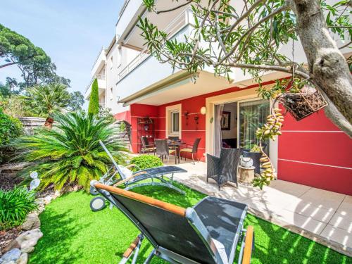 une maison rouge avec une pelouse devant elle dans l'établissement Apartment Cap Marine-8 by Interhome, à Cavalaire-sur-Mer