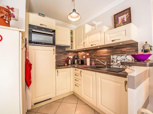 une cuisine avec des armoires blanches et un évier dans l'établissement Apartment Cap Marine-8 by Interhome, à Cavalaire-sur-Mer