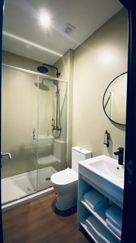 a bathroom with a shower and a toilet and a sink at Albufeira Lounge Hotel in Albufeira
