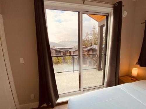 a bedroom with a bed and a large window at Haven On The Hill in Port Renfrew