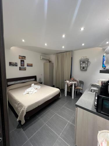 a bedroom with a bed and a kitchen with a microwave at Nel Cortile Suite in Cefalù