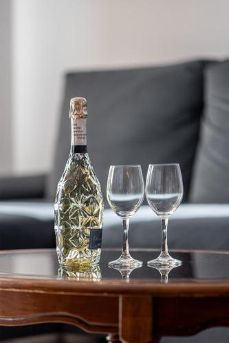 a bottle of wine and two wine glasses on a table at Moris Boutique Beach Hotel in Gdańsk