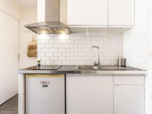 une cuisine avec des armoires blanches et un évier dans l'établissement Apartment Les Raisins d'Or-4 by Interhome, au Cap d'Agde