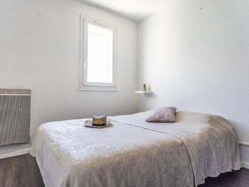 Cette chambre blanche dispose d'un lit et d'une fenêtre. dans l'établissement Apartment Les Raisins d'Or-4 by Interhome, au Cap d'Agde