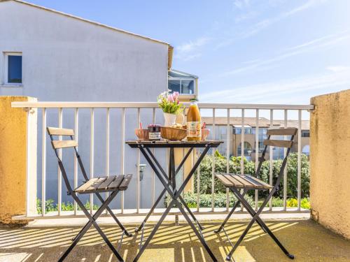 une table et deux chaises sur un balcon dans l'établissement Apartment Les Raisins d'Or-4 by Interhome, au Cap d'Agde