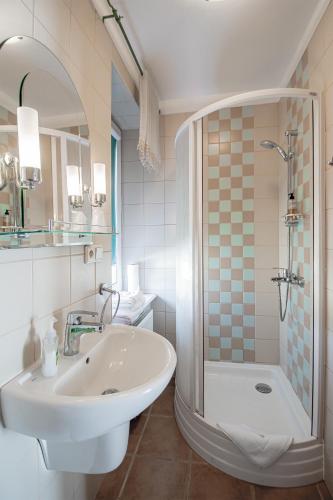 a white bathroom with a sink and a shower at Moris Boutique Beach Hotel in Gdańsk