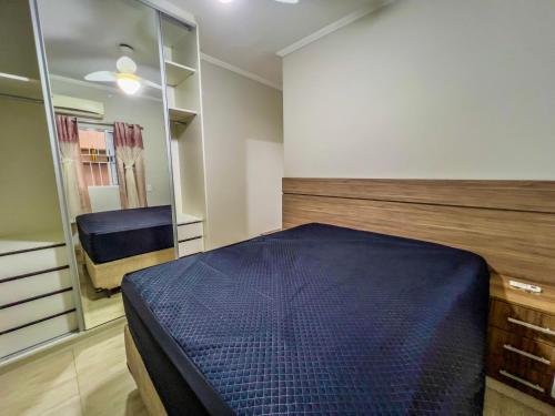 グアルジャにあるR17 · Churrasqueira Privativa, pet friendlyのベッドルーム(青いベッド1台、鏡付)