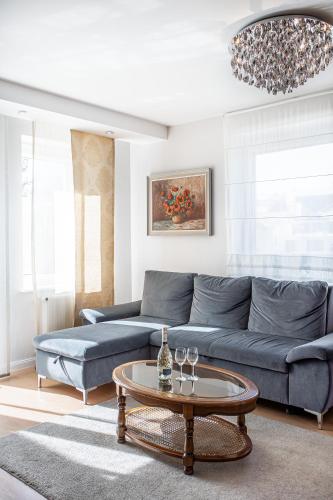 a living room with a blue couch and a table at Moris Boutique Beach Hotel in Gdańsk
