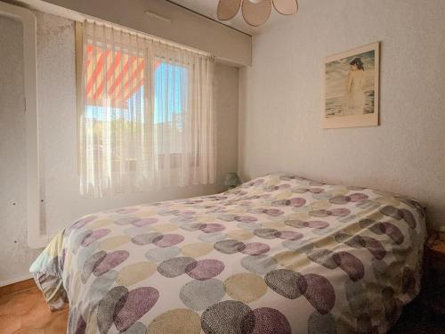 une chambre avec un lit avec une couette et une fenêtre dans l'établissement L'ivoire classed 2étoiles pied dans l'eau, à La Londe-les-Maures