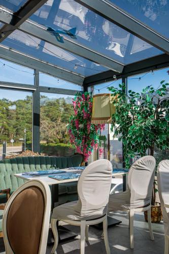 a conservatory with a table and chairs and a table and windows at Moris Boutique Beach Hotel in Gdańsk