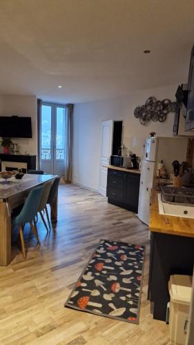 une cuisine et une salle à manger avec une table et un réfrigérateur dans l'établissement l'appart, à Thiers