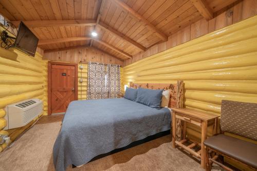 une chambre avec un lit dans une cabane en rondins dans l'établissement Ashton Log Cabins, à Ashton