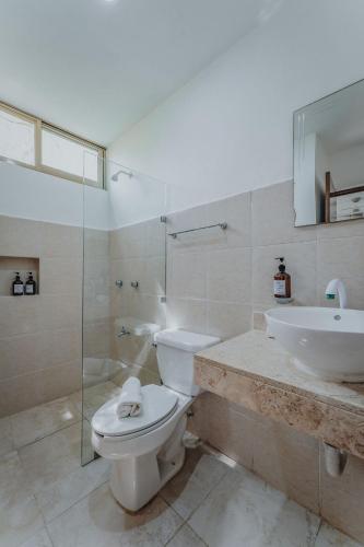 a bathroom with a toilet and a sink and a shower at Villa Xcambo San bruno in San Bruno