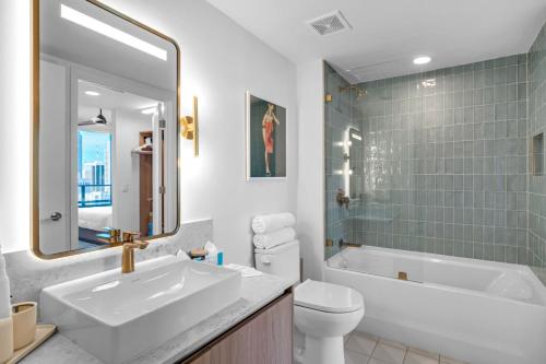 a bathroom with a sink and a tub and a toilet at Bright and Breezy 1 Bed Unit With Water and City Views in Miami