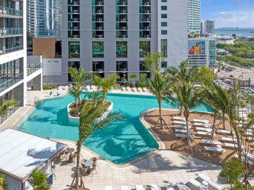 an overhead view of a swimming pool with palm trees and buildings at Bright and Breezy 1 Bed Unit With Water and City Views in Miami