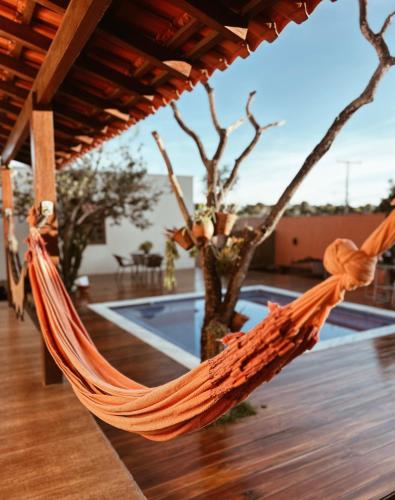 アウト・パライーゾ・デ・ゴイアスにあるVila Bonita Guest Houseのプール付きのパティオにあるオレンジ色のハンモック