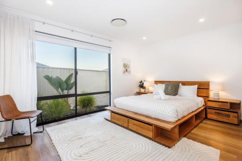 Un dormitorio con una cama y una ventana grande. en Pet-friendly. Bright and Spacious Dunsborough Home, en Dunsborough