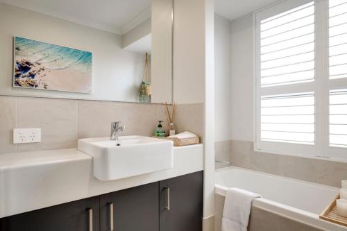 a white bathroom with a sink and a bath tub at Beachwood Escape - Dunsborough Private Getaway in Dunsborough