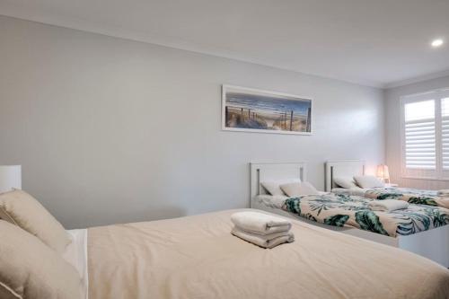 a white bedroom with two beds and a window at Beachwood Escape - Dunsborough Private Getaway in Dunsborough