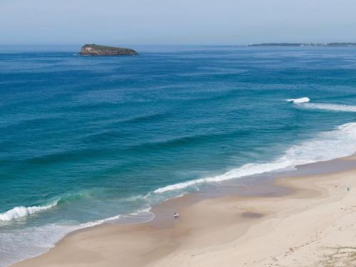 an aerial view of a beach with the ocean at Coastal Cove in Budgewoi