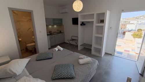 a room with a bed and a kitchen with a clock at Cyclades Studios in Parikia