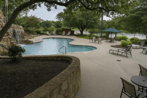 フリスコにあるSpacious 4BR Home in Frisco Ideal for Long Staysの石壁のスイミングプール