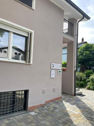 a white building with a sign on the side of it at Bed & Breakfast L'Albero Maestro in Borgofranco dʼIvrea