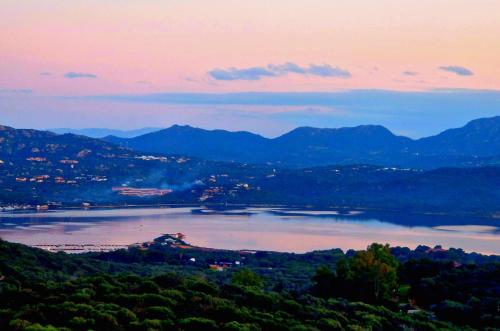a view of a lake at sunset with mountains at SOL Y LUNA 11 Apartment in Sardinia close to the beach and to Olbia airport in Olbia