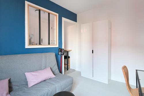 - un salon avec un canapé gris et un oreiller rose dans l'établissement Studio bleu, au Havre