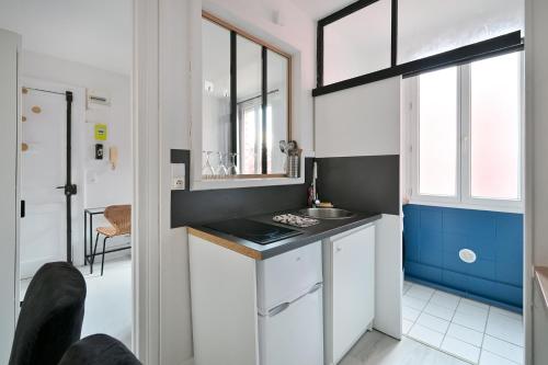 une petite cuisine avec un évier et un comptoir dans l'établissement Studio bleu, au Havre