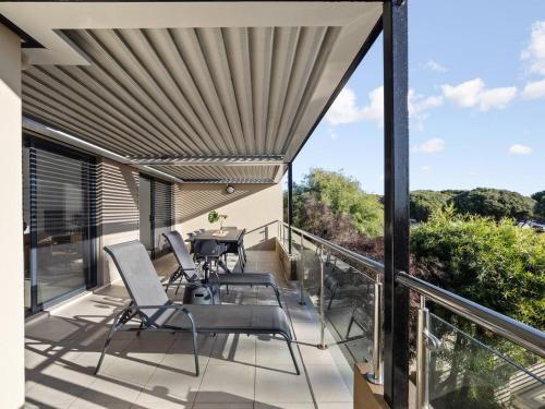 a patio with chairs and a table on a balcony at Seventh Heaven Surfside in Yallingup