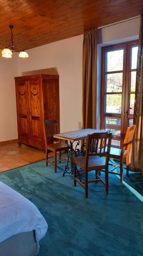a bedroom with a table and chairs and a window at Penzion Ztracený mlýn in Slapy
