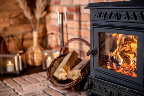 a stove with a fire in a room with candles at Hankówka Mazury in Jerutki